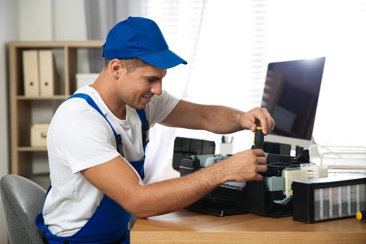 A technical fixing a printer, showing how to fix printer problems